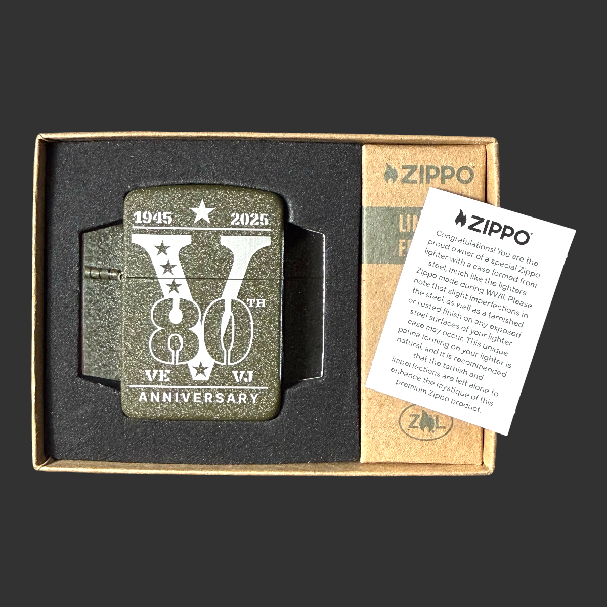 2025 Zippo 80th Anniversary WWII Victory lighter open in kraft gift box with Zippo certificate card – V for Victory engraving visible on olive green steel case