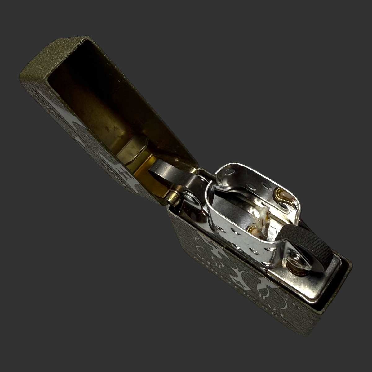 2025 Zippo 80th Anniversary WWII Victory lighter open – top-down view showing chrome insert mechanism and hinge detail on olive green textured steel case