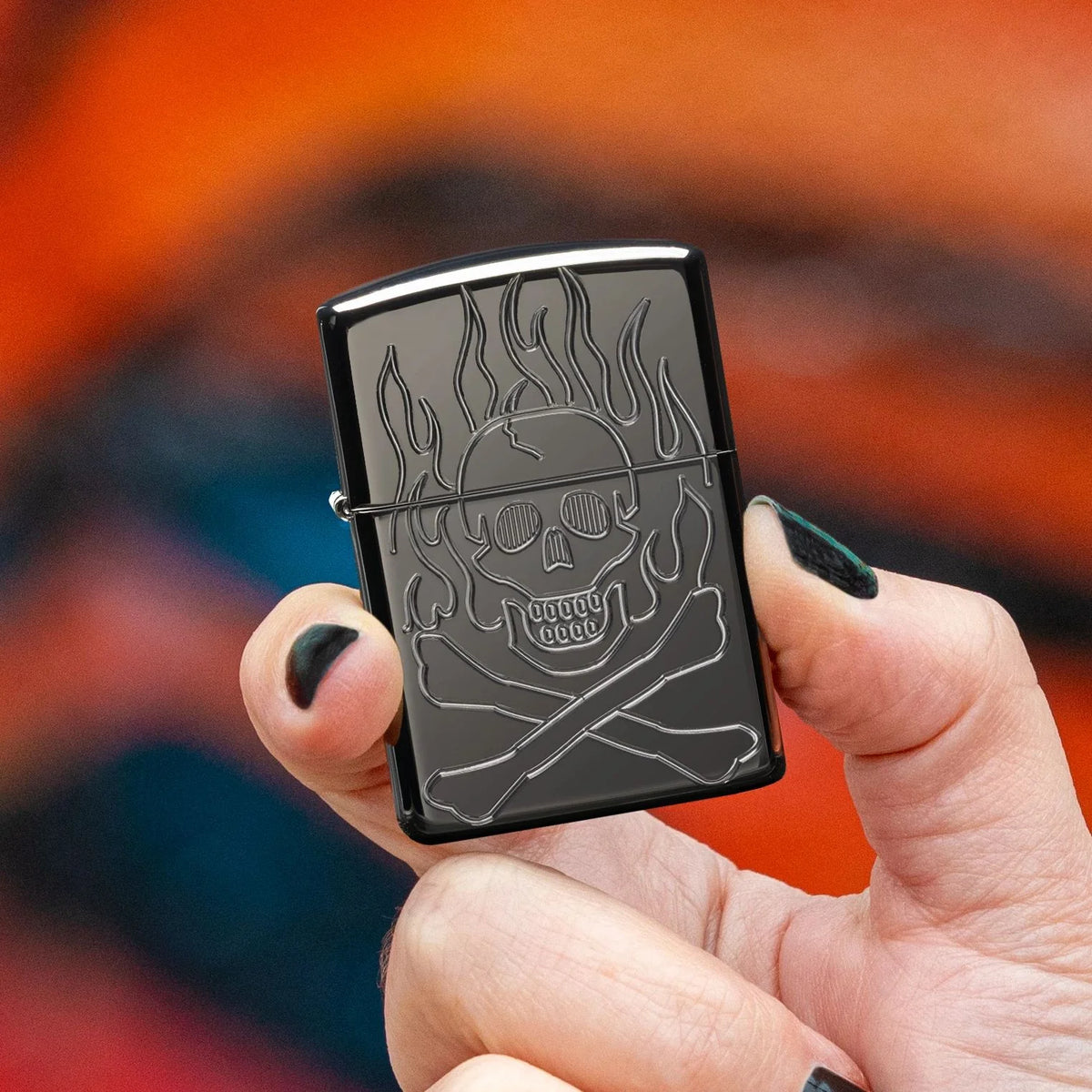 High Polish Black Armor Zippo lighter with Deep Carve flaming skull and crossbones design in hand with black nail polish